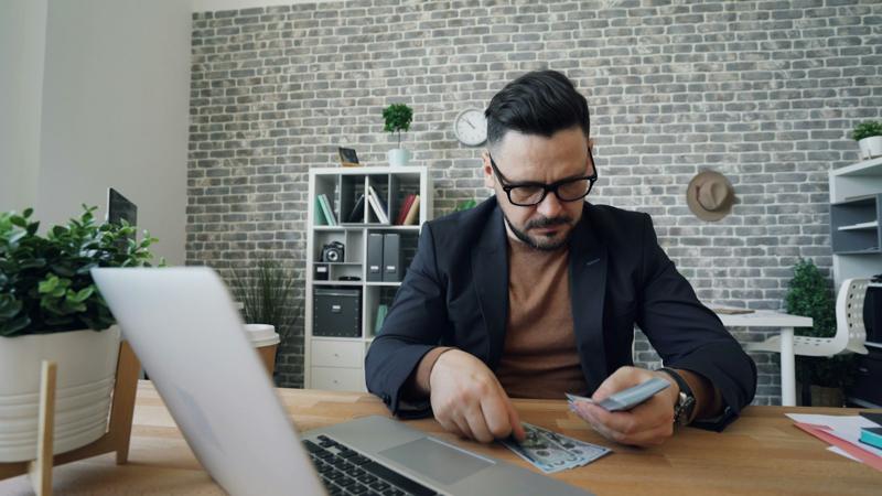 Homem trabalhando com laptop e calculadora no escritório
